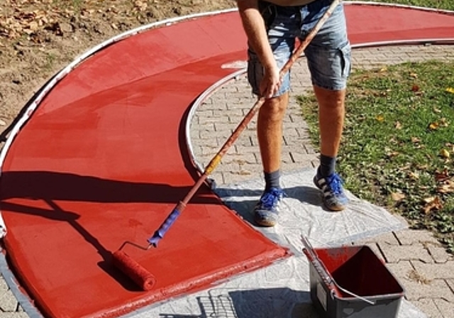 Eis- und Badmeister Markus Ernst <em>streicht den Belag der Minigolfanlage.zVg</em>
