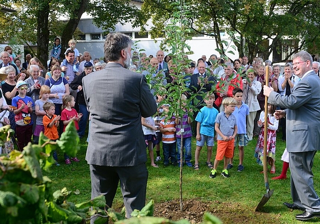 OK-Präsident und der Kirchenpflegepräsident beim Pflanzen des Apfelbaums.Fotos: bär/zVgDie Ausstellung, vor der die beiden Sigristen Hansruedi Roth (r.) und Thomas Bächli mit Pfarrerin Miriam Anne Liedtke posieren, ist bis November geöffnet.Voll