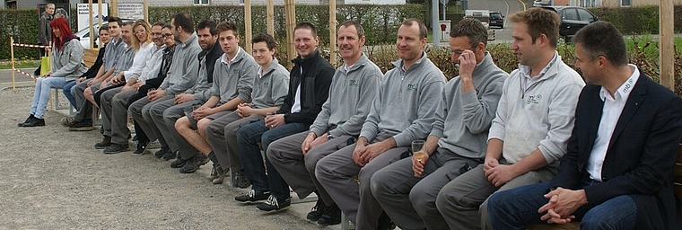 Die Belegschaft der Holzwerkstatt auf der von ihr hergestellten Bank. Foto: zVg