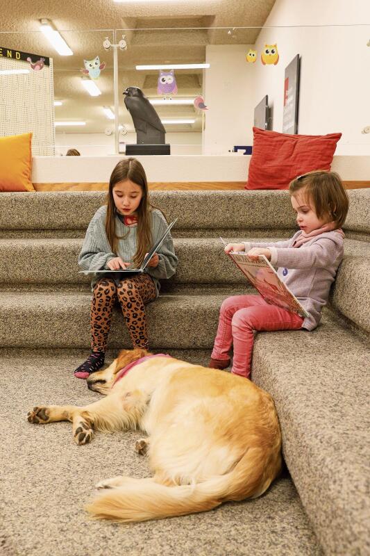 Die bald 10-jährige Eleonora (l.) liest Mila eine Geschichte vor, während die 4-jährige Elodie ein Bilderbuch anschaut. gk