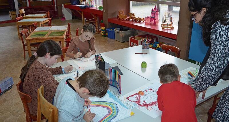 Die Kinder malen fleissig an ihren Bildern, Iman (rechts) unterstützt sie dabei. Irene Hung-König