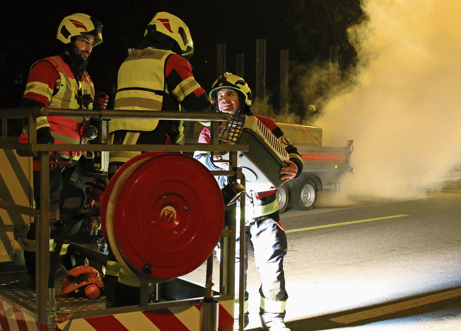 Feuerwehrleute bringen gerettete (Plüsch-)Katze in Sicherheit. bär