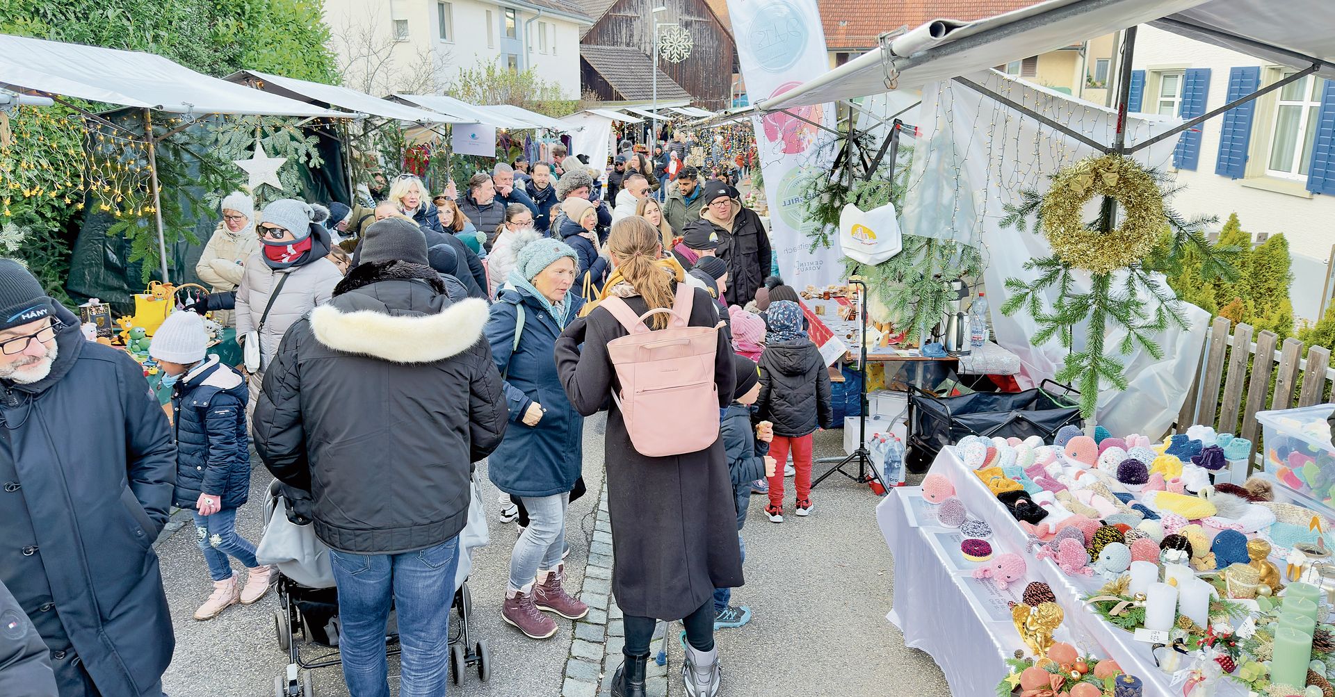 Viele Personen spazieren entlang den bunt gemischten Weihnachtsständen. Ian Stewart Viele Personen spazieren entlang den bunt gemischten Weihnachtsständen. Ian Stewart