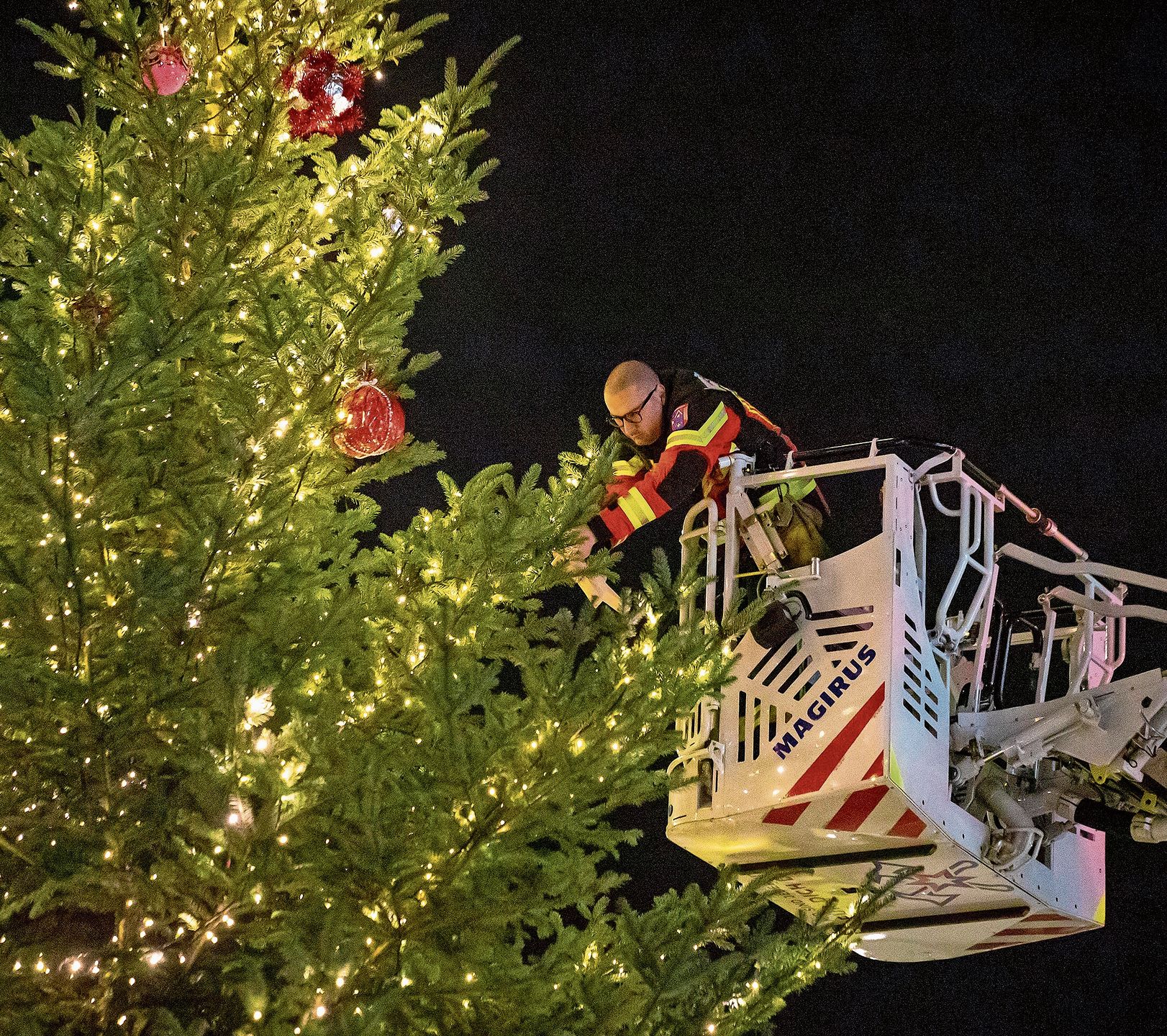 Mithilfe der Autodrehleiter wird der Schmuck aufgehängt. reg Mithilfe der Autodrehleiter wird der Schmuck aufgehängt. reg