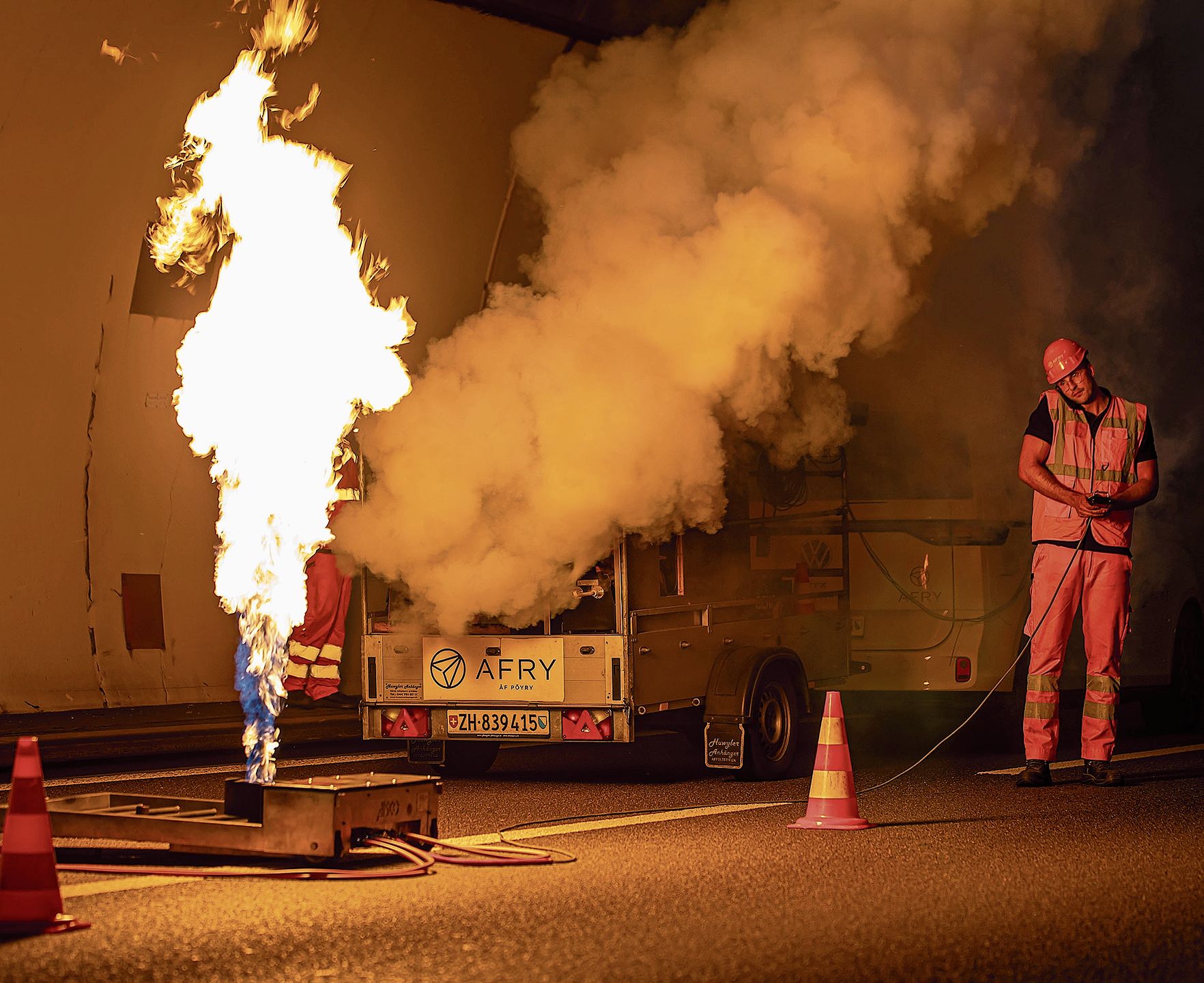 Markus Bernecker, Ingenieur AFRY Schweiz AG, zündet das Feuer mittels modernster Wasserbad-Propangasbrenner-Technologie und startet gleichzeitig die fünf Spezialrauchgeneratoren für den stationären Warmrauchversuch.Fotos: Roger Egloff