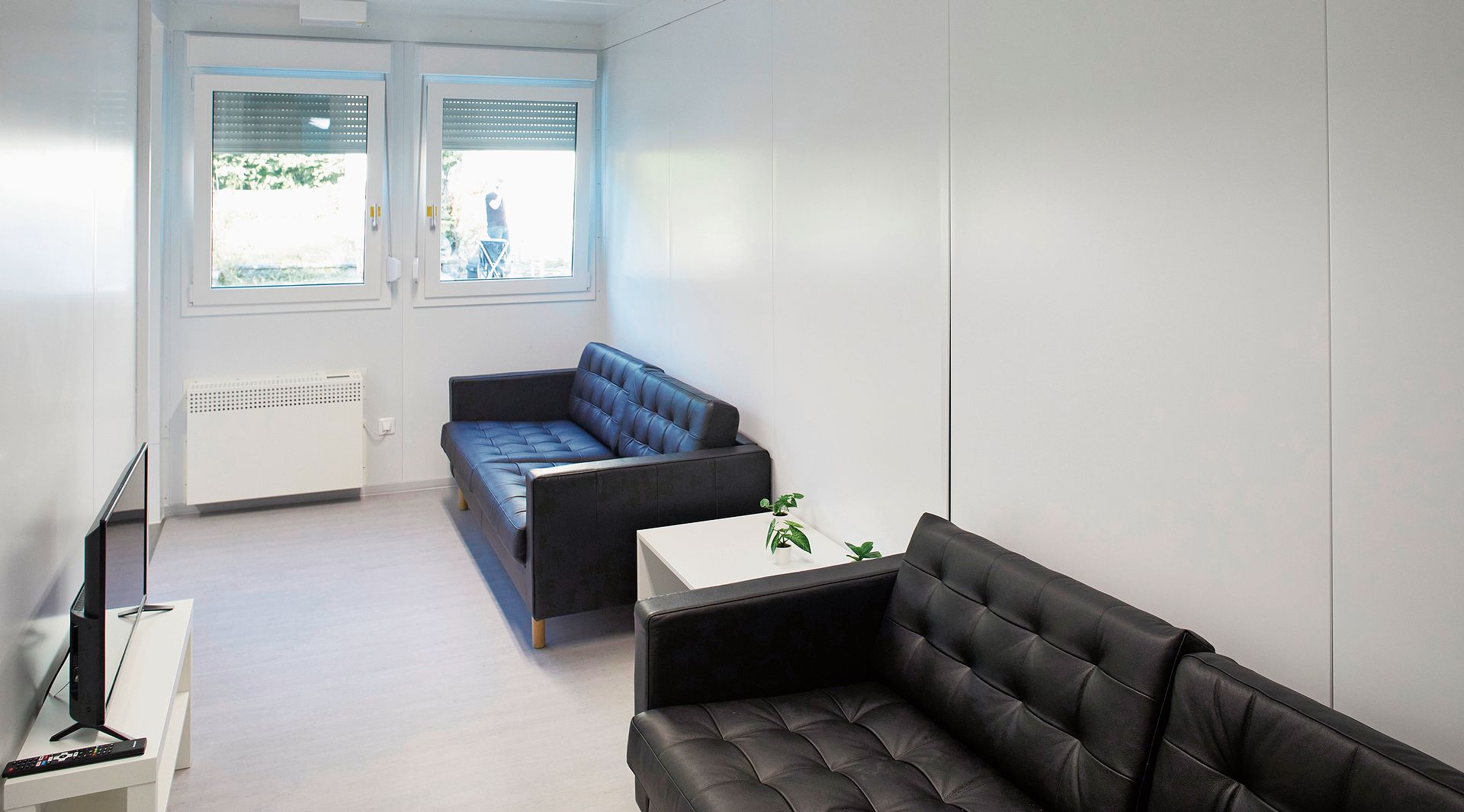 Das Wohnzimmer mit zwei Sofas und einem Fernseher. Das Wohnzimmer mit zwei Sofas und einem Fernseher.