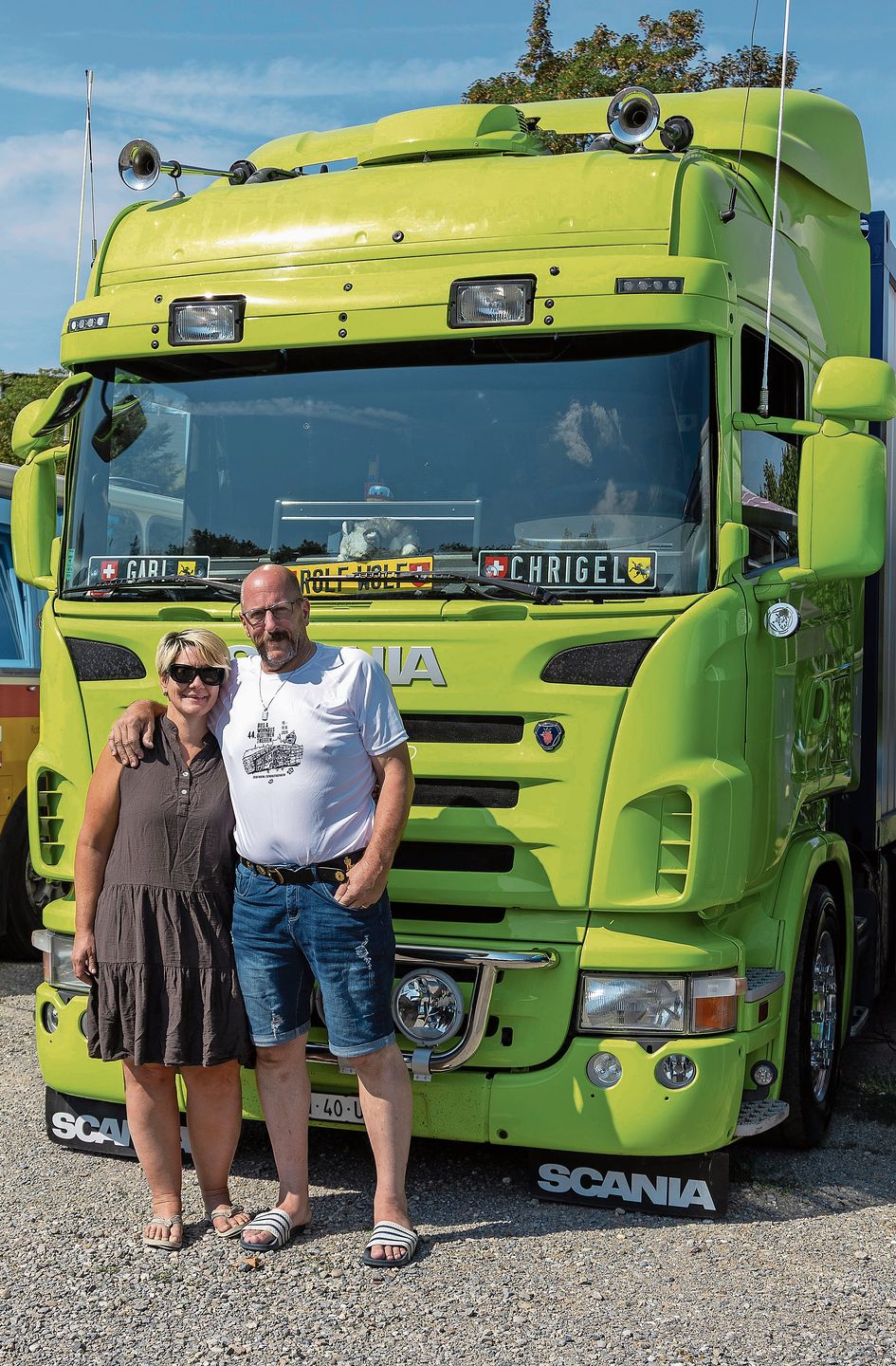 Gabi und Chrigel Oberhänsli vor ihrem Scania-Wohnlastwagen. Hinten führen sie ein Quad mit. 