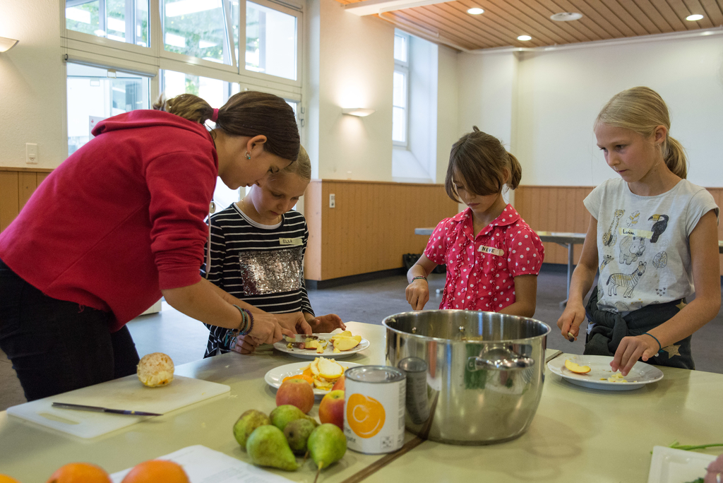 Die Kinder bereiten Fruchtsalat vor.
