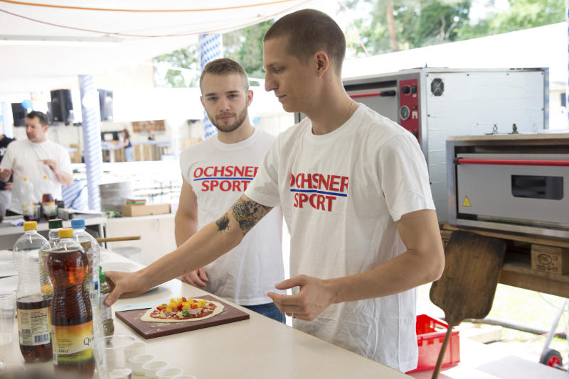 Fleissig werden Pizzas belegt. (bsc)
