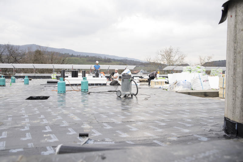 Auf dem Dach des Hallenbades laufen die Arbeiten auf Hochtouren. (Barbara Scherer)
