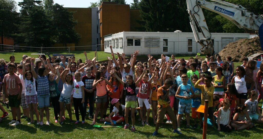Im Anschluss an die offiziellen Ansprachen durften sechs Kinder vom Schulhausrat, mit Helmen und Neonwesten ausgerüstet, sowie Schulleiterin Bettina Stade mit ihrem pinken Helm auf dem Bagger Platz nehmen,
