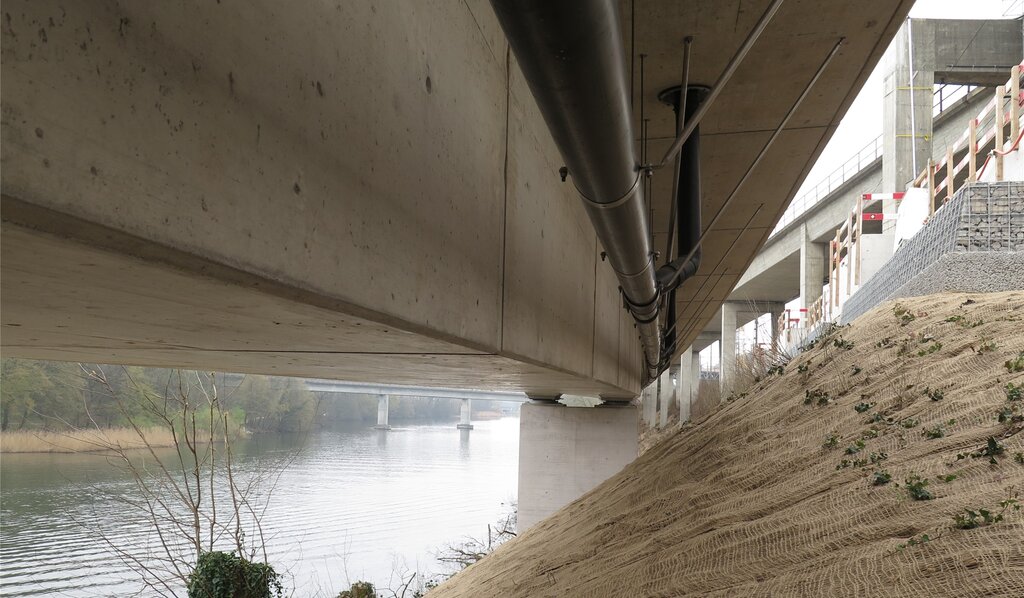 Das Lehnenviadukt steht direkt am Flussuferauf sechs Pfeilern. Im Hintergrund die Eisenbahnbrücke nach Würenlos, rechts oben das bestehende Heitersbergviadukt.
