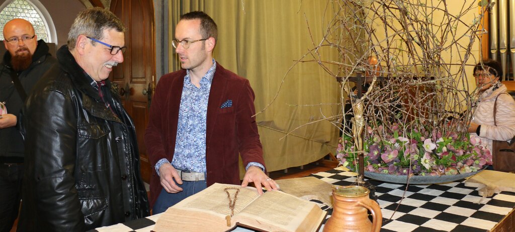 Der Wettinger Urs Iten (m.) zeigt einem Besucher, was er zum Thema «Tafeln unter Mönchen» geschaffen hatte.
