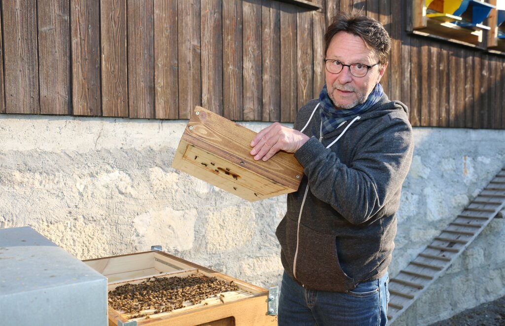 Dani Schwab gibt vor dem Bienenhaus Einblick in einen Magazinkasten.
