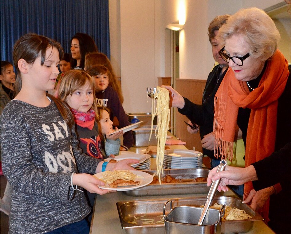 Corinne Amlehn (vorne rechts) schöpft donnerstags das Essen für die Kinder. Fotos: sw
