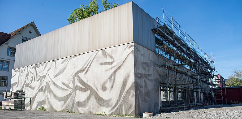 Wie ein Vorhang: Die Fassade der Aula ist einzigartig und ein Aushängeschild für die Gemeinde. Barbara Scherer
