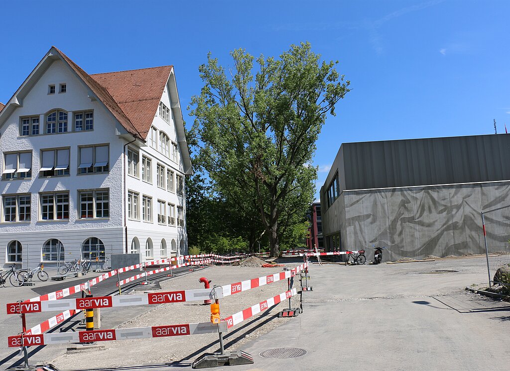 Neue Aula neben altem Schulhaus – nur noch Umgebungsarbeiten fehlen.
