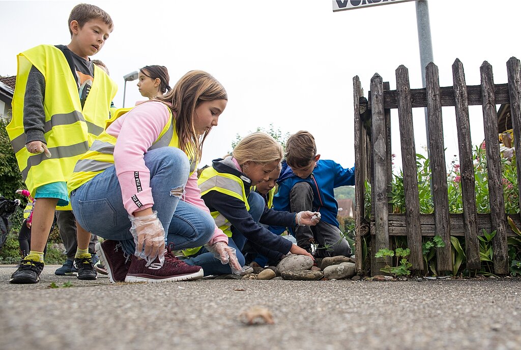 Die Kinder schauen ganz genau hin: Überall versteckt sich Abfall auf den Quartierstrassen. (Barbara Scherer)
