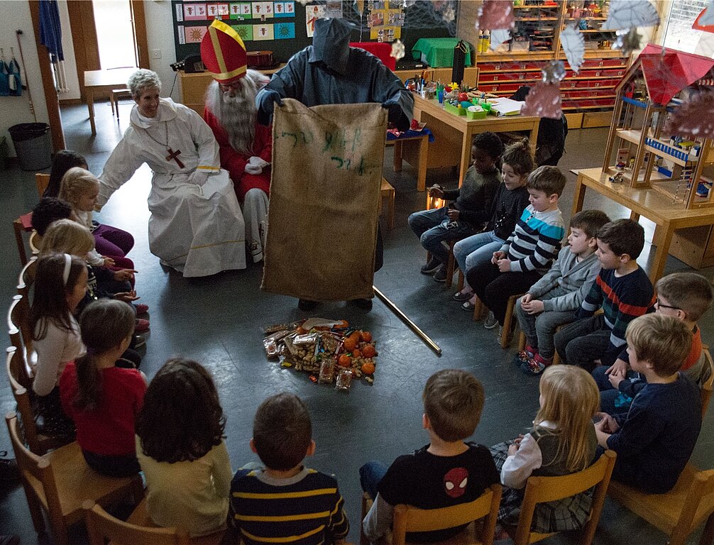 Der Schmutzli leert den Geschenkesack im Kindergarten. (bsc)