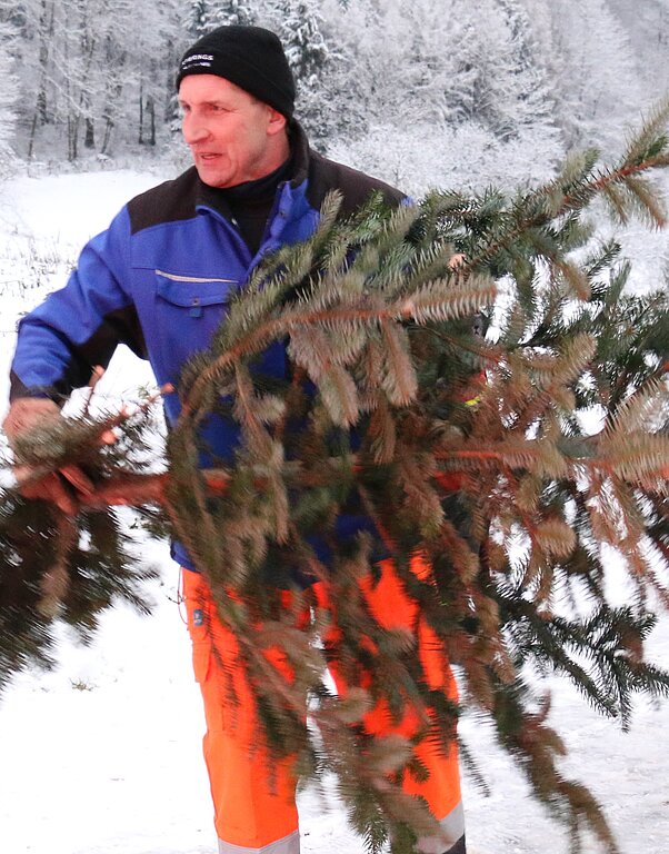 Stefan Beeler <em>nimmt die mitgebrachten Weihnachtsbäume in Empfang. (Noëlle Bär)</em>
