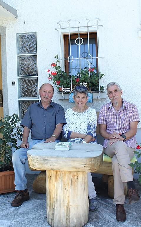 Fritz und Anita Voser mit Peter Truniger vor ihrem Haus in Neuenhof. Die Schwalbennester befinden sich über ihren Köpfen. Rahel Bühler
